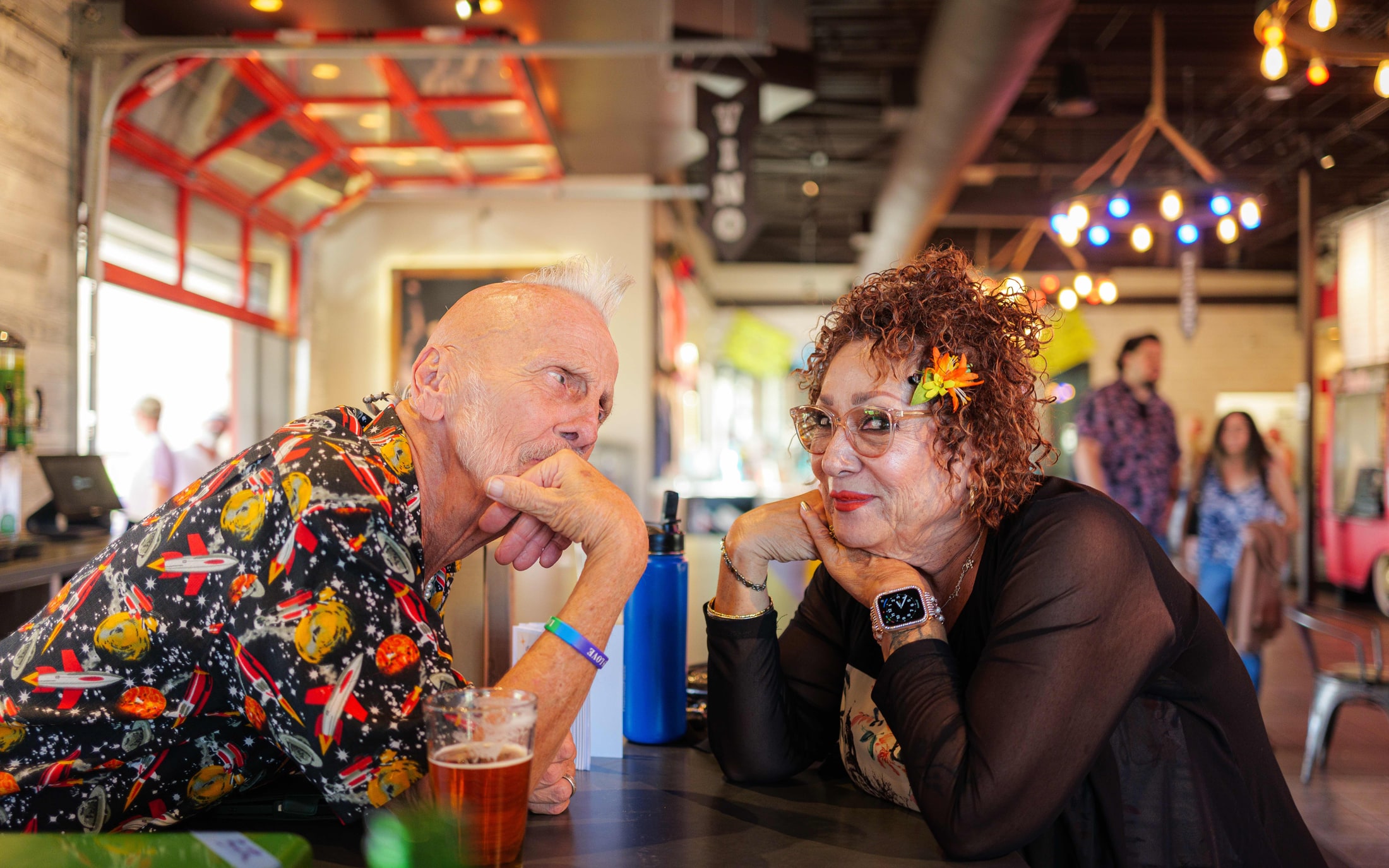 Guests chatting at a colorful bar during an evening event